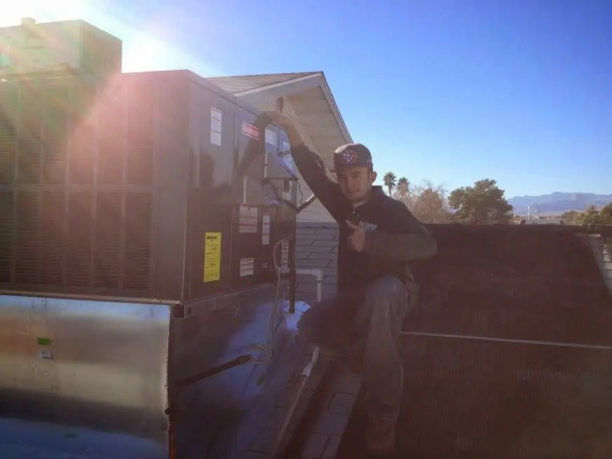 HVAC technician performing AC Tune-Up on a rooftop unit in Concord